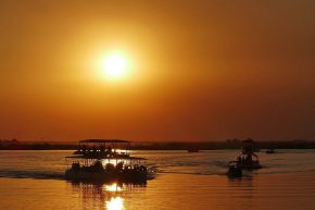 Unzählige Boote bringen sich für ein Sundowner-Foto auf dem Chobe River in Stellung.